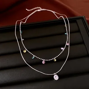 Double-layer silver-tone necklace with colorful zircon tassel pendants and a round crystal