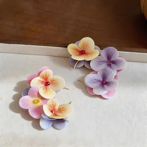 Detailed macro shot of sweet fabric flower stud earrings featuring colorful petals