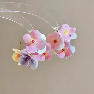 Close-up of elegant pink and purple floral petal drop earrings for a sweet vacation look