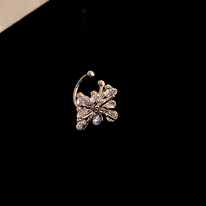 Macro view of a sparkling zircon flower ear cuff jewelry against a sleek black background