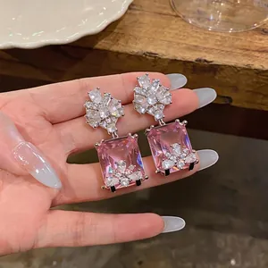 Eleganti orecchini pendenti con cristallo rosa quadrato e dettagli in zirconi chiari.