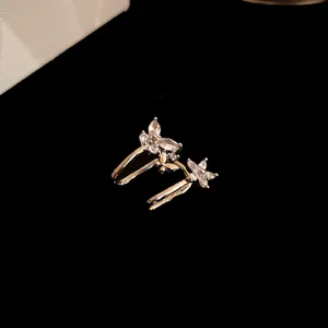 Detail view of elegant gold ear cuffs with marquise-cut zircon flower and butterfly