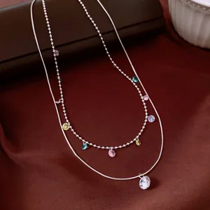Detail of vintage double-layer necklace with colorful zircons and clear pendant