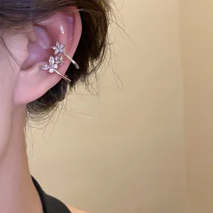 Close-up view of elegant minimalist zircon floral ear cuffs worn on model's ear