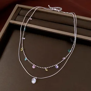 Detail view of a silver-toned double-layered necklace with colorful zircon drops for women