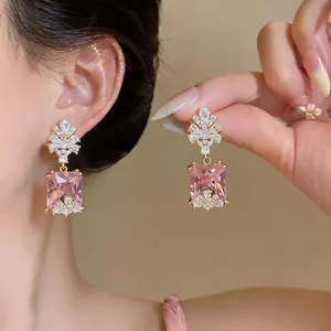 Dettaglio ravvicinato di eleganti orecchini in zircone rosa quadrato con cristalli