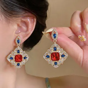 Élégantes boucles d'oreilles vintage style cour avec pierres rouges et strass bleus