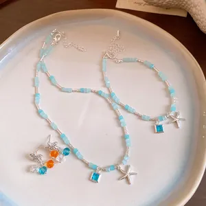Vue détaillée de l'ensemble collier, bracelet et boucles d'oreilles en perles bleues mer