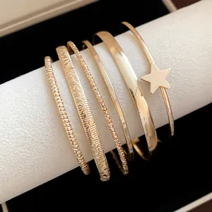 Primo piano di un set di bracciali rigidi a stella in oro rosa con trame diverse