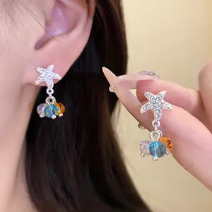 Vue détaillée de boucles d'oreilles étoile de mer argentées avec perles bleues et orange