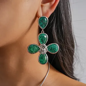 Close-up of elegant green resin four-leaf flower earrings with silver rose detail