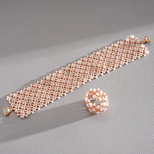 Detailed view of woven glass bead bracelet and matching ring set in rose gold tones