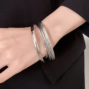 Vista dettagliata di eleganti bracciali rigidi argentati con un ciondolo a stella.
