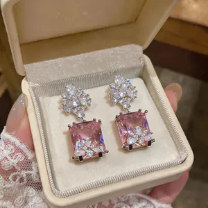 Primo piano di orecchini a goccia CZ rosa rettangolari in una scatola di lusso.