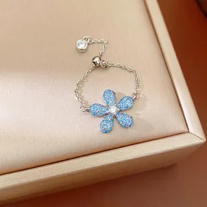 Bague ajustable en chaîne argentée avec fleur en cristal bleu et charm