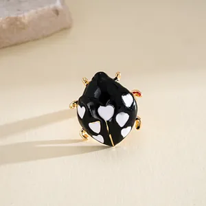 Vista macro dettagliata di un anello a coccinella in smalto nero con cuori bianchi