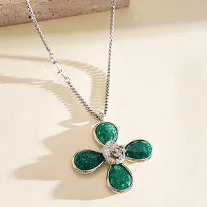 Macro view of the textured green resin petals and silver rose center on a flower necklace