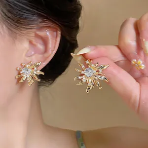 Detailed view of French vintage gold sunflower earrings with sparkling clear center stones.