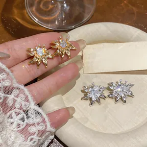 Close-up of French vintage sunflower stud earrings with sparkling crystals in gold and silver