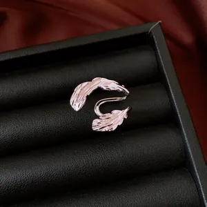 Macro view showing the intricate double-leaf hollow design of a silver ear cuff