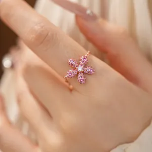 Vue détaillée d'une bague ajustable en or rose avec un motif de fleur pavée rose