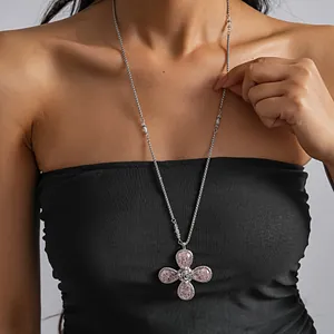 Macro view of pink resin flower pendant detail on a silver-toned sweater chain.