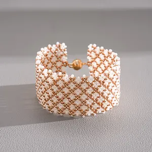 Detailed view of the geometric glass beadwork and spherical magnetic clasp of the bracelet.