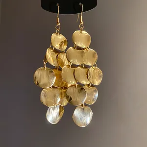 Detailed macro view showing the brushed metal texture of vintage gold tiered circular disk dangle earrings