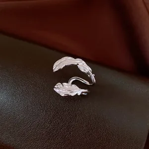 Exquisite silver-colored double-leaf hollow ear cuff accessory displayed on leather