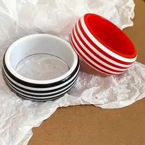 Chunky resin bangles with bold black and red striped patterns on white base