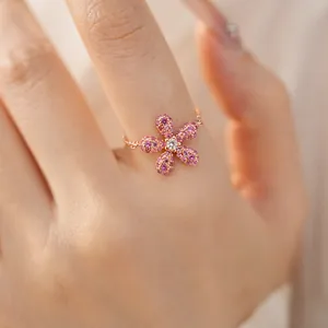 Vue rapprochée d'une bague fleur rose ajustable avec cristaux pavés sur chaîne or