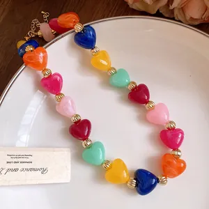 Vista detallada de cuentas de corazón de acrílico jaspeado en un collar colorido dulce.