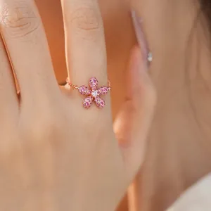 Détail macro d'une bague fleur aux cristaux roses et chaîne réglable en or rose