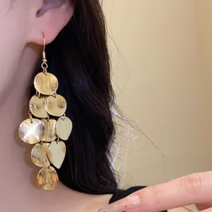 Detailed close-up showing texture of golden round geometric fringe drop earrings