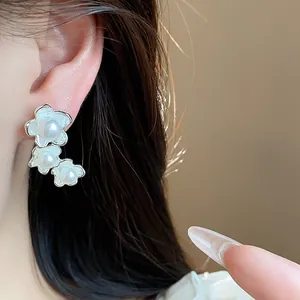 Primo piano dettagliato di orecchini francesi in argento con fiori e perle eleganti.