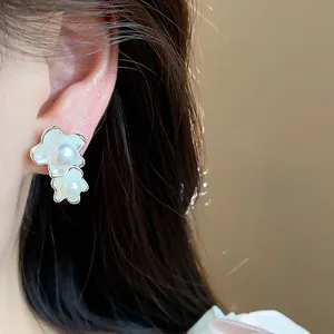 Primo piano di eleganti orecchini a lobo con fiori di perle asimmetrici in stile francese