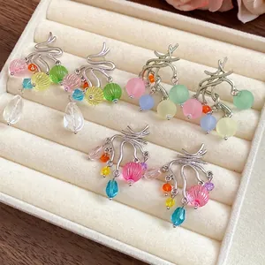 Orecchini a nappa con perle di vetro e resina colorati in un vassoio per gioielli