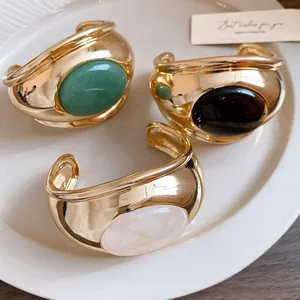 Detailed view of vintage gold cuffs with tiger eye and rose quartz stones