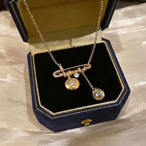 Elegant 18K gold plated necklace featuring a safety pin pendant and star star charm