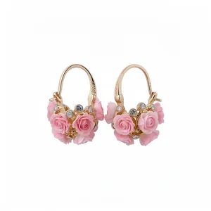 Boucles d'oreilles dorées élégantes avec roses en résine rose et strass en forme de panier fleuri.