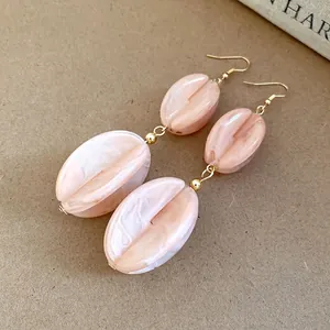 Elegant long drop earrings featuring pale pink marbled acrylic beads and gold hooks for women