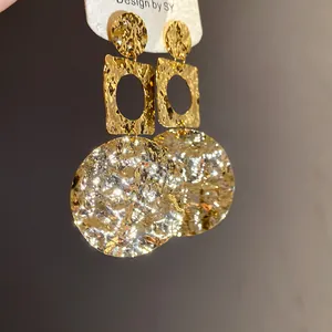 Nahaufnahme von 18 Karat vergoldeten Ohrringen mit Hammerschlag-Textur und Anhängern