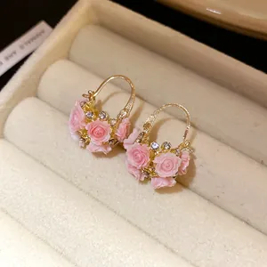 Vue détaillée de créoles panier de fleurs en résine rose avec de petits strass