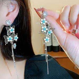 Elegant silver needle earrings featuring detailed butterfly flowers and shimmering long tassels