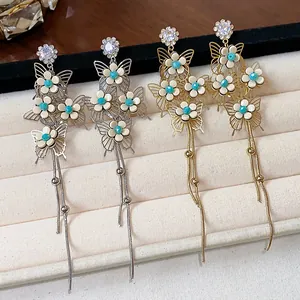 Detail view of French style butterfly and flower tassel earrings in gold and silver.