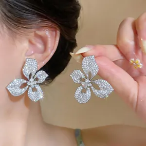 Detail view of large silver flower stud earrings with shimmering rhinestones for brides.