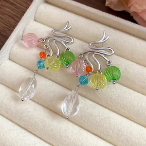 Primo piano dei dettagli di orecchini colorati con nappine in vetro e resina