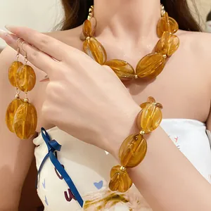 Close-up of amber acrylic swirled bead jewelry set including necklace and earrings