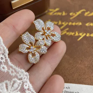 Detailed macro view of gold-plated floral stud earrings with pavé crystals