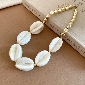 Close-up of acrylic marbled and golden beads necklace on a vintage book background